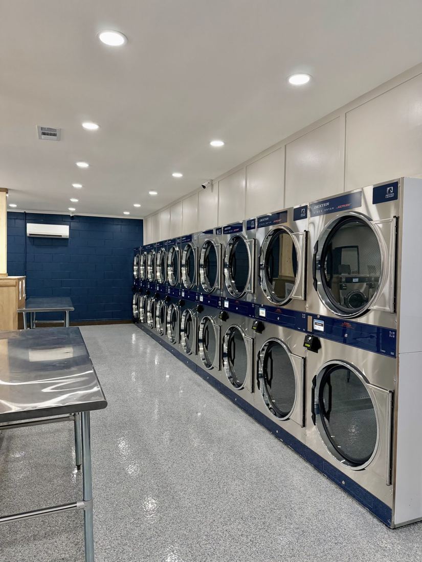 Wall of Dexter stack dryers next to a stainless folding table
