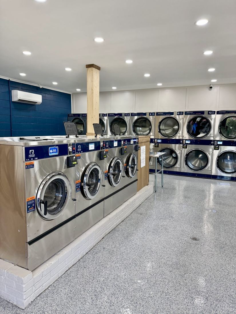 Dexter X-Series washers with touchscreens and a row of stack dryers